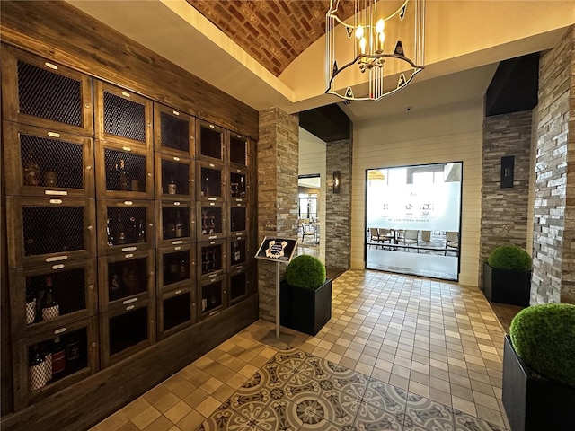 wine area featuring vaulted ceiling, brick ceiling, tile patterned floors, and an inviting chandelier