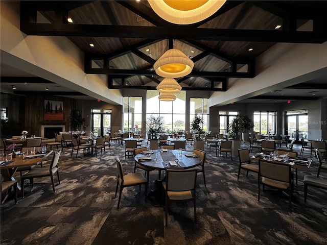 dining area with high vaulted ceiling, a wealth of natural light, and beamed ceiling