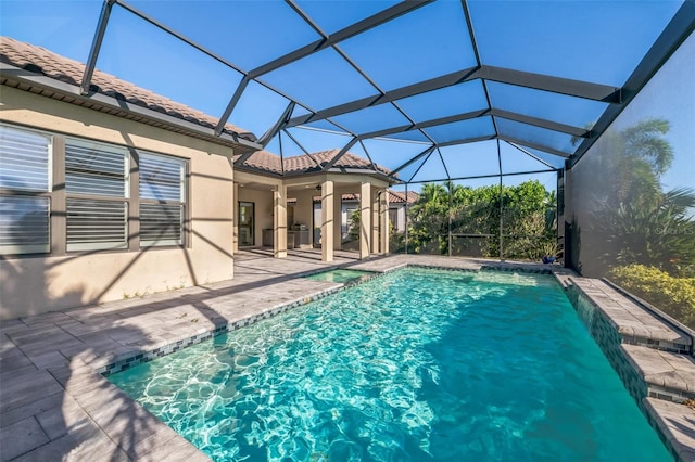 view of swimming pool with glass enclosure and a patio area