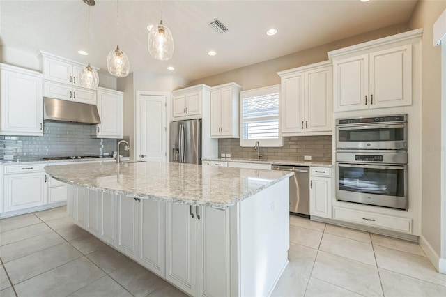 kitchen featuring pendant lighting, sink, white cabinetry, appliances with stainless steel finishes, and an island with sink