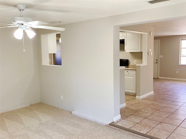 tiled empty room featuring ceiling fan