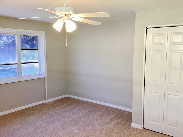 carpeted spare room with ceiling fan