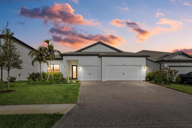 view of front of property with a garage and a yard