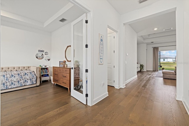 corridor featuring a raised ceiling and hardwood / wood-style flooring