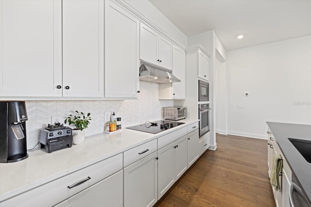 kitchen featuring tasteful backsplash, sink, white cabinetry, appliances with stainless steel finishes, and dark wood-type flooring