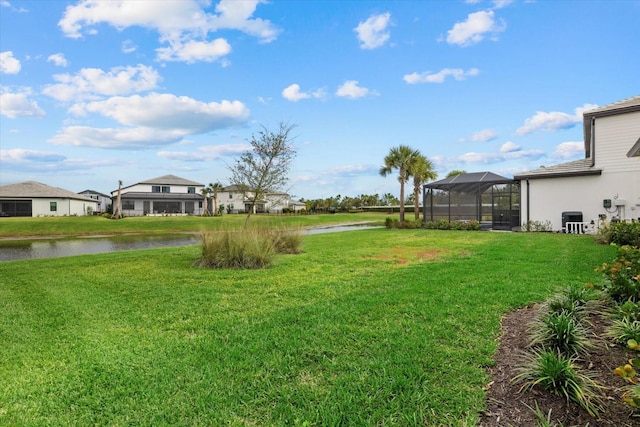 view of yard with a water view and glass enclosure