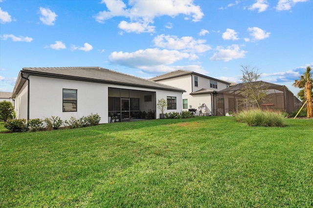 rear view of house with a lanai and a yard