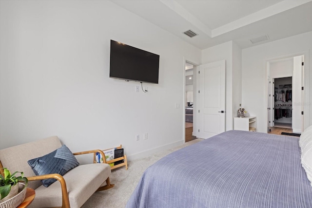 bedroom with connected bathroom and light carpet