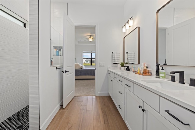 bathroom with ceiling fan, vanity, wood-type flooring, and a shower