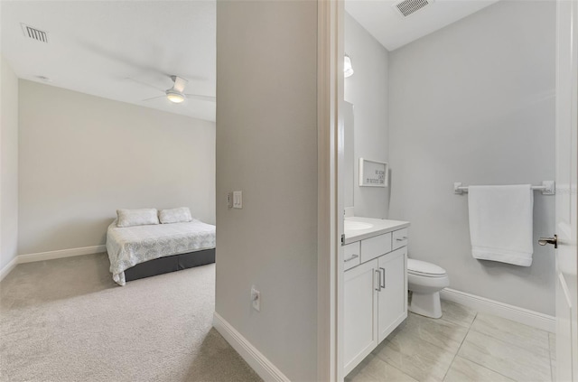 bathroom featuring toilet, vanity, and ceiling fan