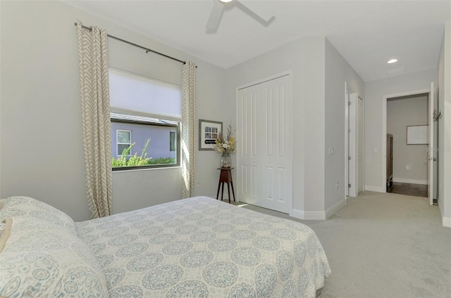 bedroom with ceiling fan, a closet, and light carpet