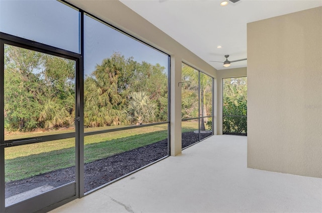 unfurnished sunroom with ceiling fan