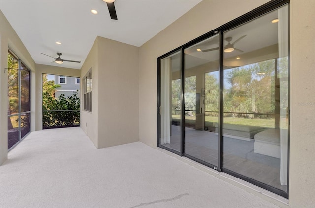 unfurnished sunroom featuring ceiling fan