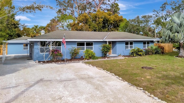 ranch-style home with a carport and a front yard