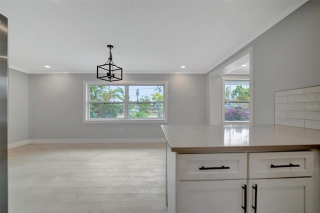 kitchen with white cabinetry, an inviting chandelier, light wood-type flooring, decorative backsplash, and pendant lighting