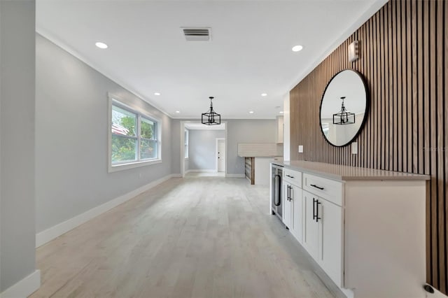 interior space with light hardwood / wood-style flooring, beverage cooler, and crown molding