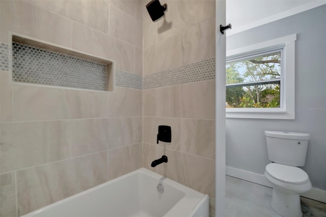 bathroom with tiled shower / bath, tile patterned flooring, and toilet