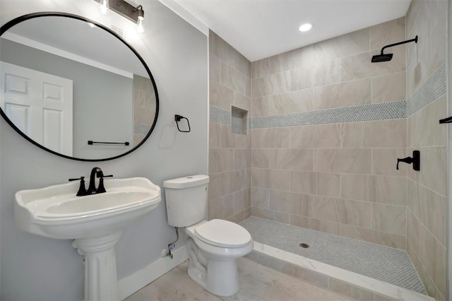 bathroom featuring toilet and a tile shower