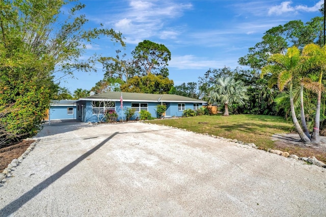 ranch-style home with a front lawn and a garage