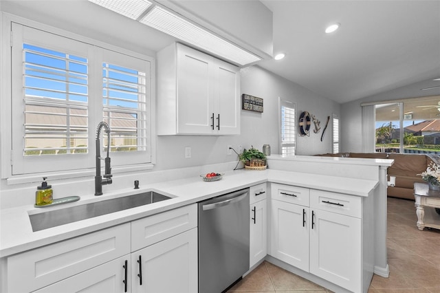 kitchen featuring dishwasher, lofted ceiling, sink, white cabinets, and kitchen peninsula