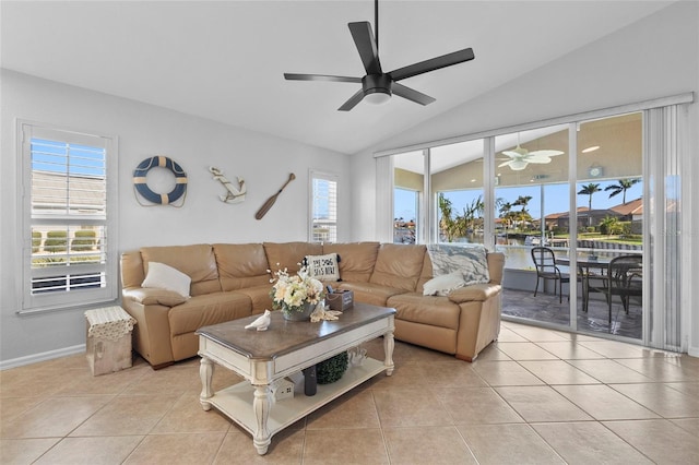 living room with light tile patterned flooring, plenty of natural light, lofted ceiling, and ceiling fan