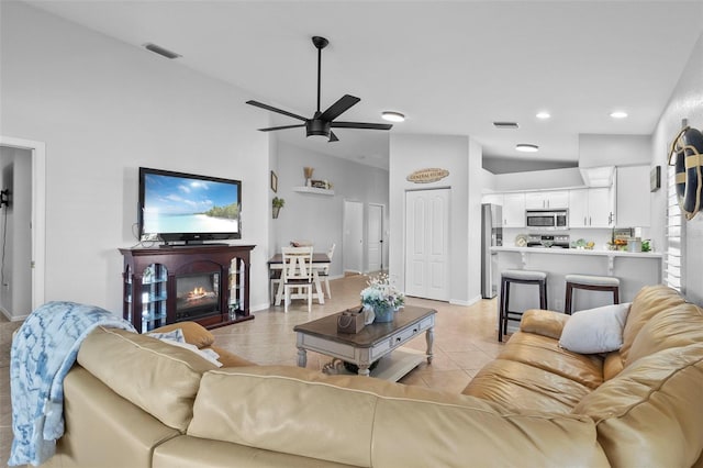 living room featuring light tile patterned flooring, vaulted ceiling, and ceiling fan