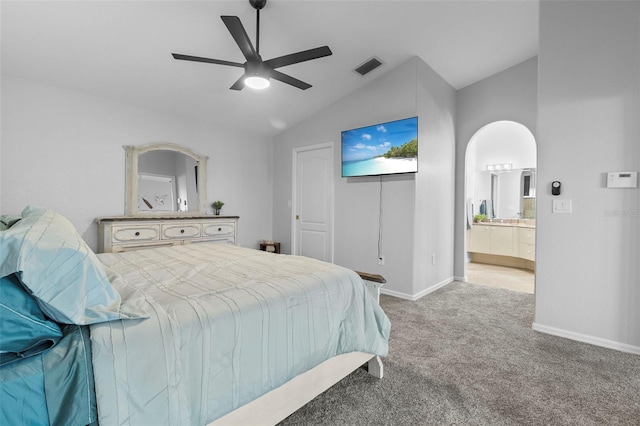 carpeted bedroom featuring lofted ceiling, connected bathroom, and ceiling fan