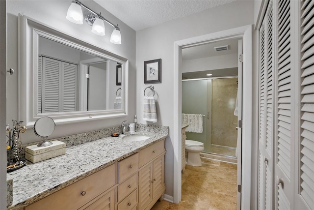 bathroom with vanity, an enclosed shower, a textured ceiling, and toilet