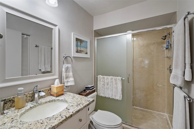 bathroom with vanity, toilet, and a shower with shower door