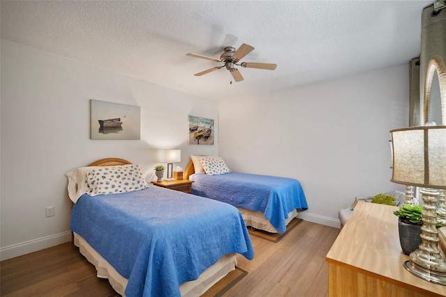 bedroom featuring wood-type flooring, a textured ceiling, and ceiling fan