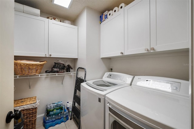 washroom with cabinets, washer and dryer, and light tile patterned flooring