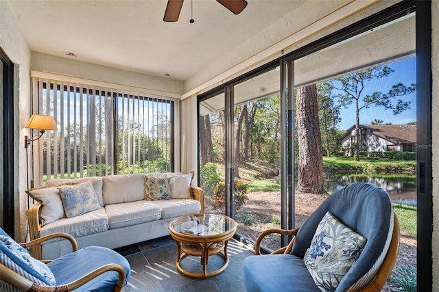 sunroom featuring a water view and ceiling fan