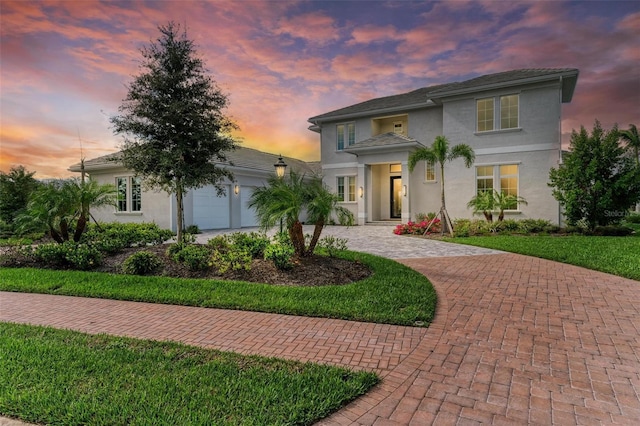 view of front facade with a yard and a garage