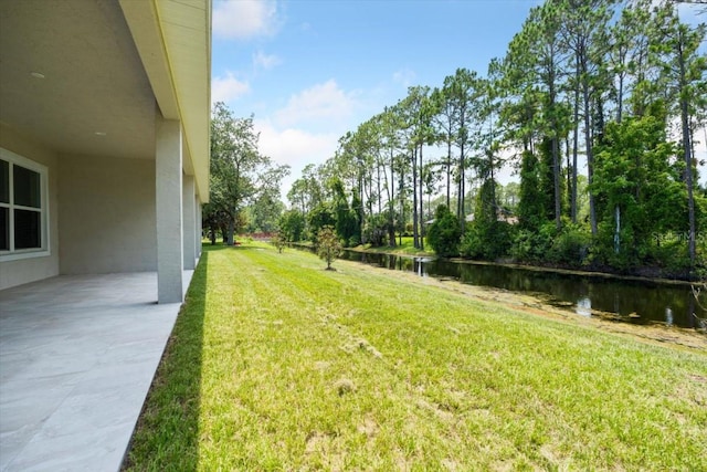 view of yard with a patio area and a water view