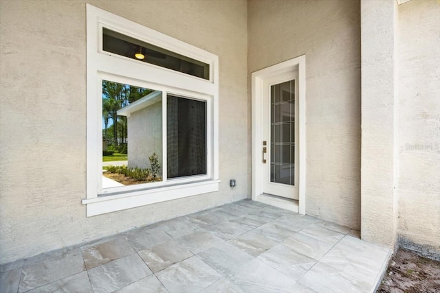 view of exterior entry with a patio