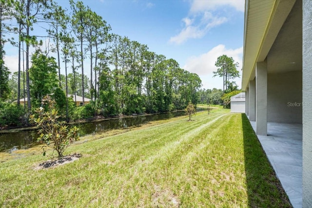 view of yard with a water view and a patio