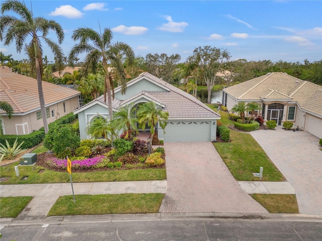 view of front facade featuring an attached garage, stucco siding, a front lawn, a tile roof, and decorative driveway