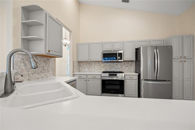 kitchen featuring a sink, open shelves, backsplash, appliances with stainless steel finishes, and light countertops