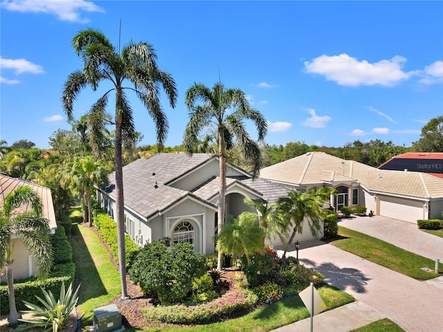 view of front of home featuring decorative driveway, an attached garage, and stucco siding