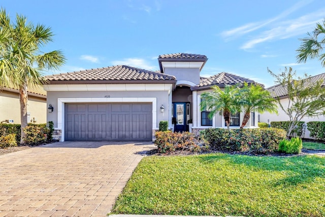 mediterranean / spanish-style home with a garage and a front yard