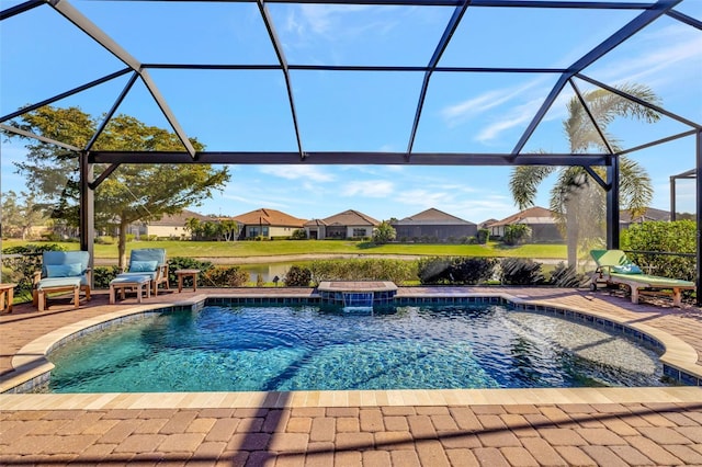 view of swimming pool featuring pool water feature, glass enclosure, and a patio area