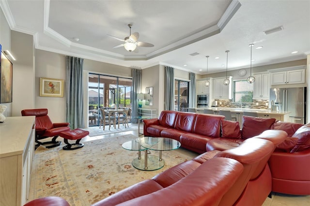 living room with crown molding, sink, ceiling fan, and a tray ceiling