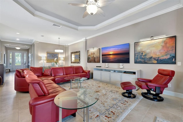 tiled living room featuring crown molding, ceiling fan, and a tray ceiling