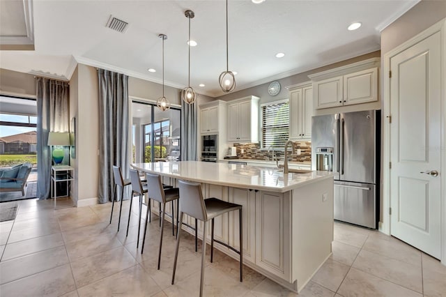 kitchen with hanging light fixtures, a wealth of natural light, high quality fridge, and a center island