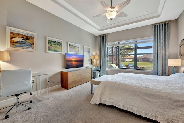 bedroom featuring a tray ceiling, carpet floors, ornamental molding, and ceiling fan