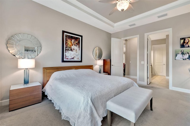 carpeted bedroom with a raised ceiling and ceiling fan