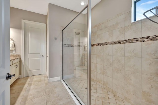 bathroom with vanity, tile patterned floors, and a tile shower