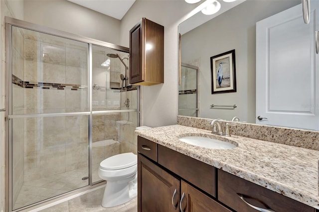 bathroom with vanity, tile patterned flooring, a shower with door, and toilet