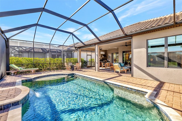 view of swimming pool featuring pool water feature, a jacuzzi, glass enclosure, ceiling fan, and a patio