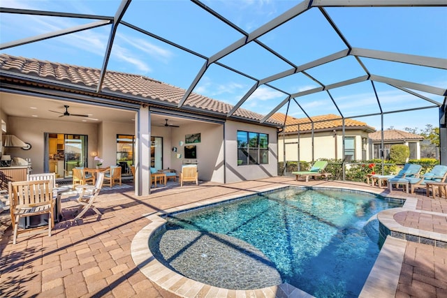 view of swimming pool featuring a patio area, ceiling fan, and glass enclosure